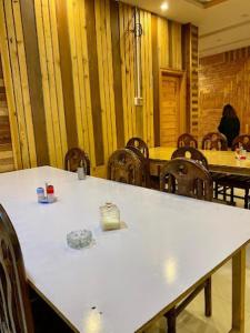 Malam Jabba的住宿－Sunshine Hotel & Restaurant，一间会议室,配有桌椅和白色的桌子