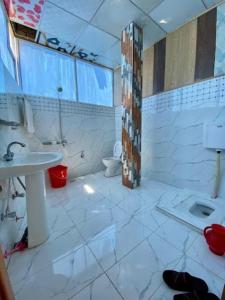 Malam Jabba的住宿－Sunshine Hotel & Restaurant，一间带水槽和卫生间的浴室