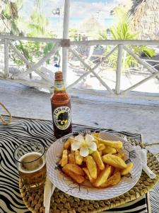 um prato de batatas fritas e uma garrafa de cerveja em 3 bedrooms house at Watamu 100 m away from the beach with shared pool furnished terrace and wifi em Watamu