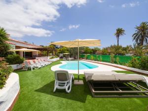 podwórko z basenem z krzesłami i parasolem w obiekcie CASA GRAN CANARIA - Gran Canaria Stays w mieście Maspalomas