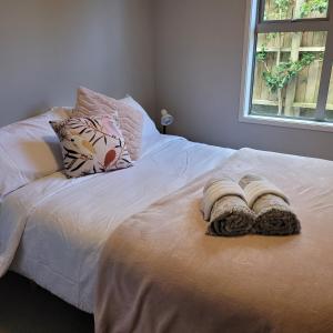 uma cama com duas toalhas com uma janela em The Coop em Kinloch