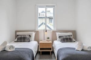 two twin beds in a room with a window at Beautiful Balmain Abode - Balmain, NSW in Sydney