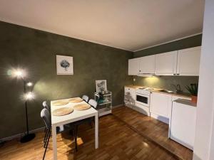 een keuken met een witte tafel en een keuken met witte kasten bij Apartment with Terrace & View in Bergen