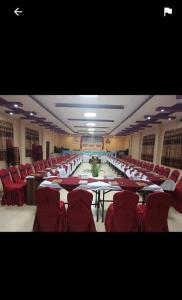 a banquet hall with red chairs and tables in a room at Doleshwor Village Resort & Farm House Pvt. Ltd. in Bhaktapur