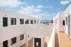 an external view of a white building with a walkway at Apartamentos Bella Vista in Puerto del Carmen