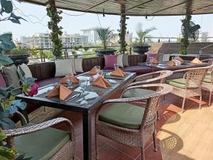 Maisonette Hotels & Resorts في لاهور: فناء مع طاولات وكراسي وأريكة