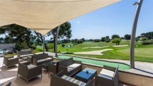 a patio with a view of a golf course at La Calade in L'Isle-sur-la-Sorgue