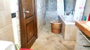 ein Badezimmer mit einer Holztür und einem Waschbecken in der Unterkunft 2 bedrooms house with sea view furnished terrace and wifi at Castelmola 5 km away from the beach in Castelmola