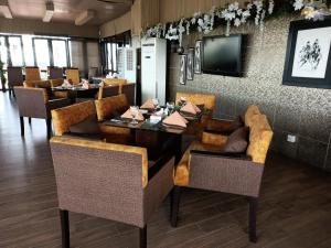 un restaurante con comedor con mesas y sillas en Maisonette Hotels & Resorts en Lahore