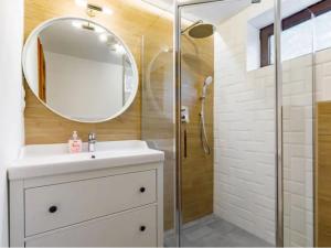 La salle de bains est pourvue d'un lavabo et d'une douche avec un miroir. dans l'établissement Green Lake House - Private beach at Balaton, à Balatonakarattya