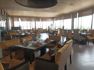 Maisonette Hotels & Resorts في لاهور: غرفة طعام مع طاولات وكراسي ونوافذ