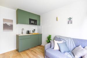 un salon avec un canapé et une cuisine dans l'établissement Lavie Maison Equipped Studio, à Bordeaux