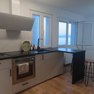 a kitchen with a counter with a sink and a stove at Curota A in Ribeira