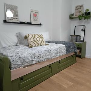 a bed with a green frame in a bedroom at Curota A in Ribeira