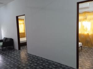 a room with a white wall and a mirror at Homestay Idaman B B with 2 room aircond 2 Quen Bed and Not Sharing Room -Privacy in Kuala Terengganu
