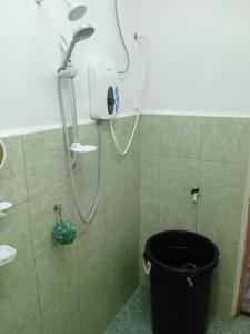 a shower in a bathroom with a trash can at Homestay Idaman B B with 2 room aircond 2 Quen Bed and Not Sharing Room -Privacy in Kuala Terengganu