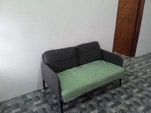 a couch with a green seat in a room at Homestay Idaman B B with 2 room aircond 2 Quen Bed and Not Sharing Room -Privacy in Kuala Terengganu