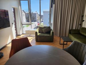 a living room with a table and chairs and a large window at PÄRNU CENTER in Pärnu
