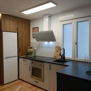 a kitchen with a refrigerator and a stove top oven at Curota A in Ribeira +9 photos