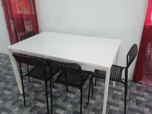 a white table with four chairs in a room at Homestay Idaman B B with 2 room aircond 2 Quen Bed and Not Sharing Room -Privacy in Kuala Terengganu