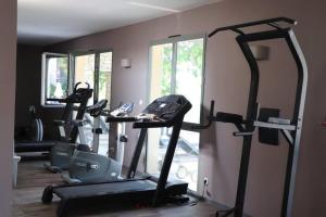 a gym with several tread machines in a room at La Calade in L'Isle-sur-la-Sorgue