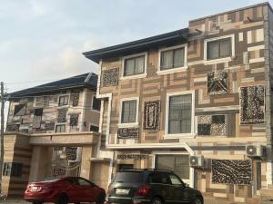 a building with two cars parked in front of it at Cozy Haven Suite in Accra