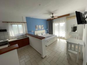 a room with a bed and a kitchen with a tv at Adult Only - Hotel Suzanna in Achladies