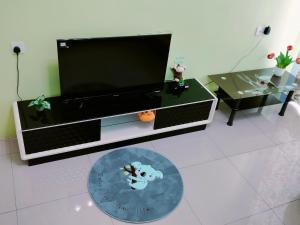een woonkamer met een flatscreen-tv en een tafel bij Idea Homestay 1 in Chemor