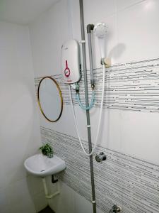 een douche in de badkamer met een wastafel en een spiegel bij Idea Homestay 1 in Chemor
