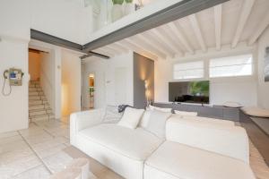 a living room with a white couch and a tv at Jesolo Beach Villa in Lido di Jesolo