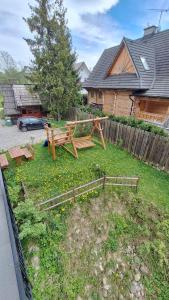een tuin met een houten bank in een tuin bij Willa U Kośle 2 in Zakopane