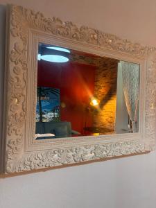 a mirror with a white frame on a wall at Villa delle mimose in Sestri Levante
