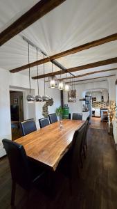 Hisa Brdo Guesthouse في تولمين: غرفة طعام مع طاولة وكراسي خشبية كبيرة