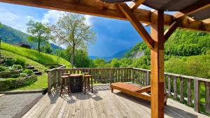 a deck with a bench and a table and a grill at Hisa Brdo Guesthouse in Tolmin