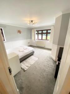 Un dormitorio blanco con una cama y una ventana. en Emerson Park Mansion, en Harold Wood