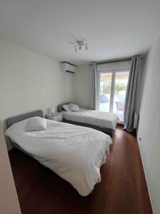 two beds in a room with a window at Beautiful apartment - Centre in Cagnes-sur-Mer