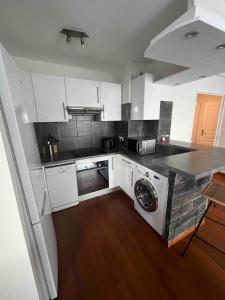 a kitchen with white cabinets and a washing machine in it at Beautiful apartment - Centre in Cagnes-sur-Mer