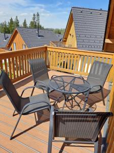 un patio avec trois chaises et une table sur une terrasse dans l'établissement Lipno Village Houses, à Frymburk