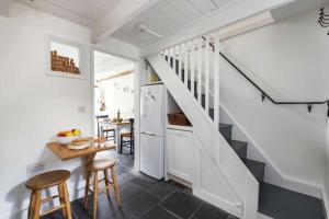 eine Küche mit Treppe und Tisch und Stühlen in der Unterkunft Gull's Nest Holiday Cottage in Mousehole + 15 Fotos