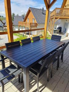 une table bleue et des chaises sur une terrasse dans l'établissement Lipno Village Houses, à Frymburk