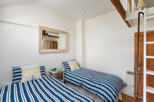 zwei Betten in einem Zimmer mit weißen Wänden in der Unterkunft Gull's Nest Holiday Cottage in Mousehole