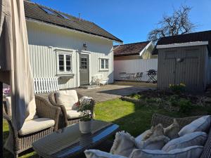 patio z krzesłami i stołem na dziedzińcu w obiekcie Cozy Central House w mieście Sandefjord