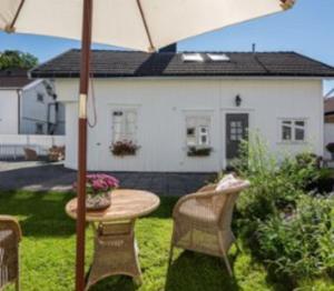 a patio with a table and chairs and an umbrella at Cozy Central House in Sandefjord