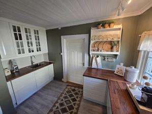 kuchnia z białymi szafkami i blatem w obiekcie Cozy Central House w mieście Sandefjord
