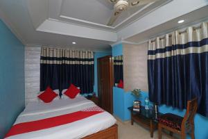 a bedroom with a bed and a desk and curtains at OYO A G Residency & Son in Bumlitan