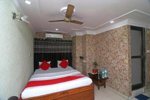 a bedroom with a bed with red pillows on it at OYO A G Residency & Son in Bumlitan