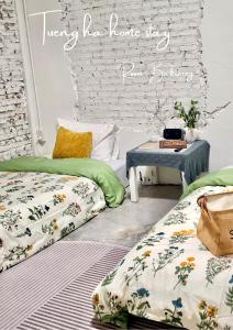 a room with two beds and a table and a brick wall at Tueng ha เติง หา ที่พักงาว in Ban Rong