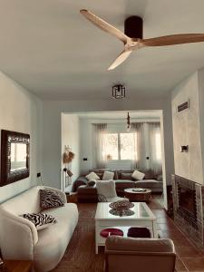 uma sala de estar com um sofá e uma ventoinha de tecto em Villa Oasys em Almeria