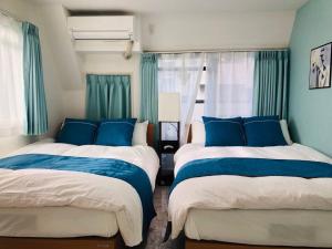 2 camas en una habitación de color azul y blanco en シティマインド京町802, en Osaka