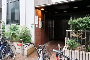 dos bicicletas estacionadas frente a un edificio en シティマインド京町802, en Osaka